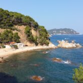 Paysage côtier estival avec la mer en contrebas, entouré de différents reliefs montagneux