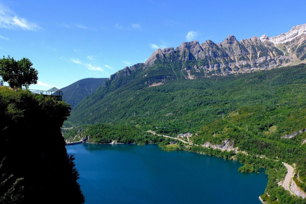 Paysage de montagne en été avec en contrebas un lac de montagne et en fond des sommets