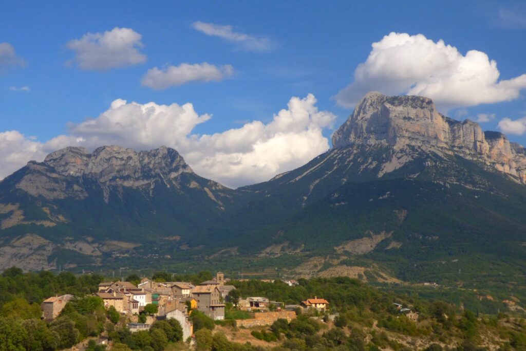 Paysage estival avec une plaine et des villages en contrebas et en arrière-plan des sommets