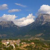 Paysage estival avec une plaine et des villages en contrebas et en arrière-plan des sommets