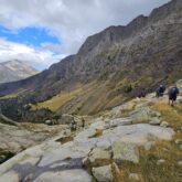 Randonneurs sur un sentier descendant une montagne et poursuivant leur randonnée du tour des Posets avec leur guide