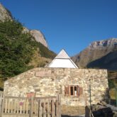 Paysage de montagne avec une maison en pierre.