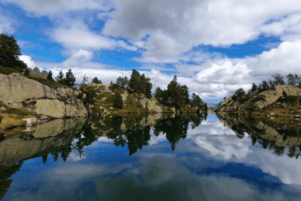 Lac de montagne avec reflets des reliefs dans l'eau dans les Encantats.