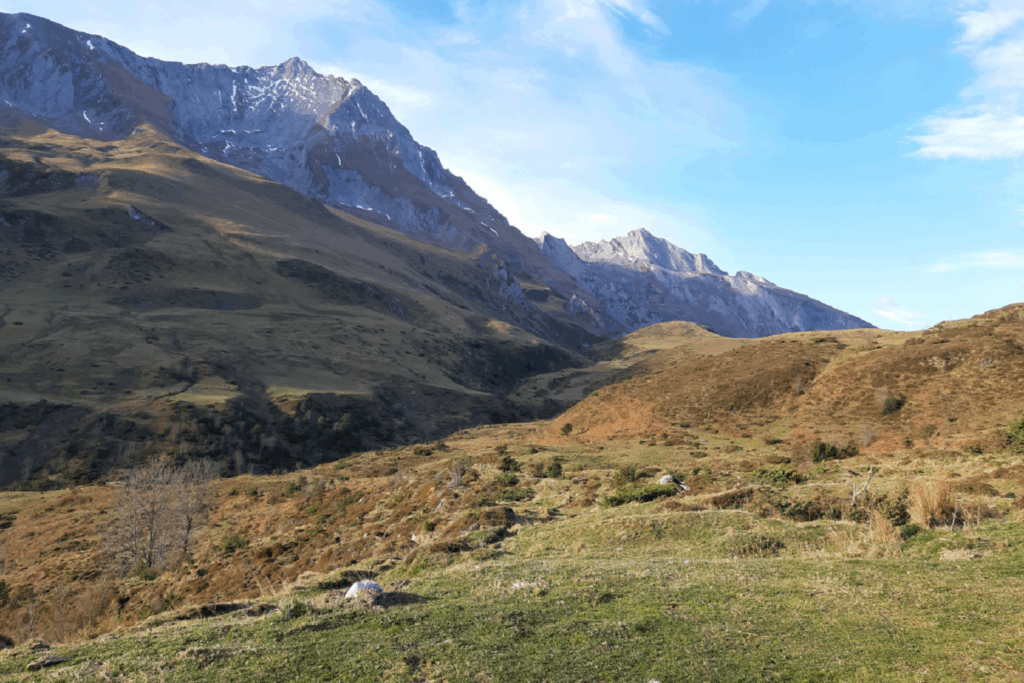 Paysage montagnard avec en arrière-plan des sommets et au premier plan un plateau de verdure