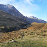 Paysage montagnard avec en arrière-plan des sommets et au premier plan un plateau de verdure