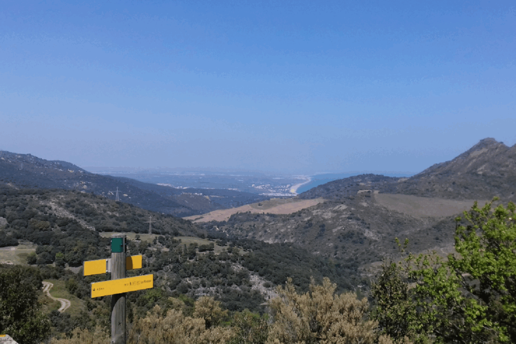 Paysage de montagne avec des panneaux indicatifs de direction et une vallée en arrière-plan
