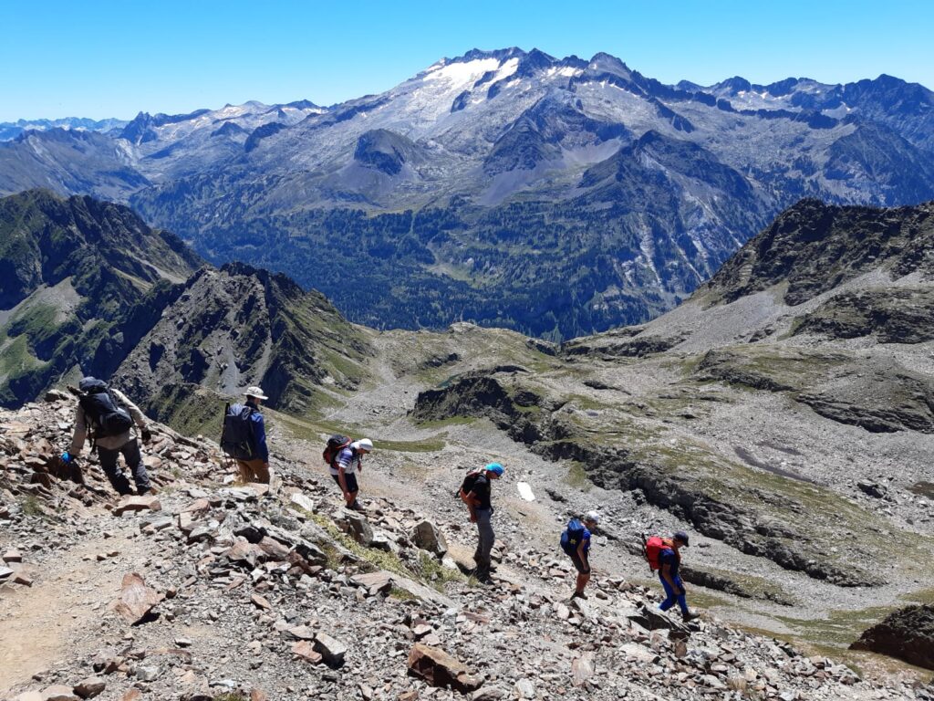 groupe de randonneurs dans le massif de l'Aneto en train de descendre sur un sentier de pierres