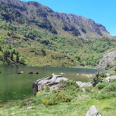 Lac de montagne entouré de sommets et de végétation