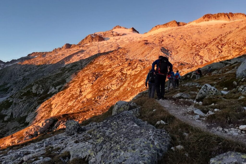 Paysage montagnard, prise de vue faite au lever du soleil, avec un groupe de marcheurs sur un sentier