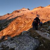 Paysage montagnard, prise de vue faite au lever du soleil, avec un groupe de marcheurs sur un sentier