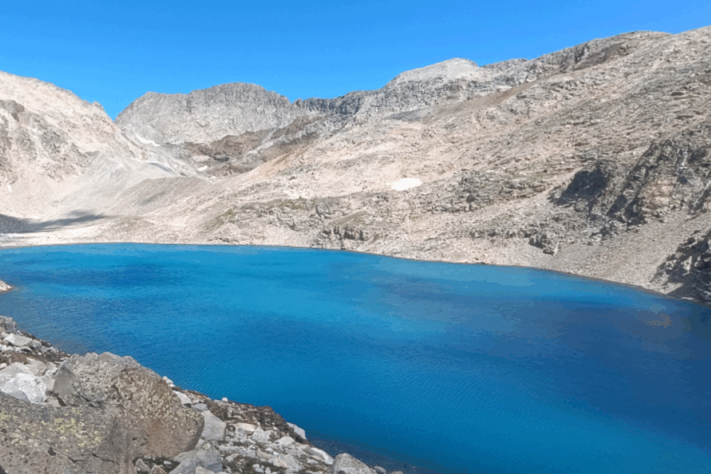 Lac de montagne bleu entouré de montagnes grises