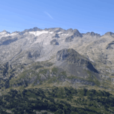 paysage montagneux du massif de l'Aneto où l'on observe une forêt en contrebas ainsi que des restes de neige en haut des sommets