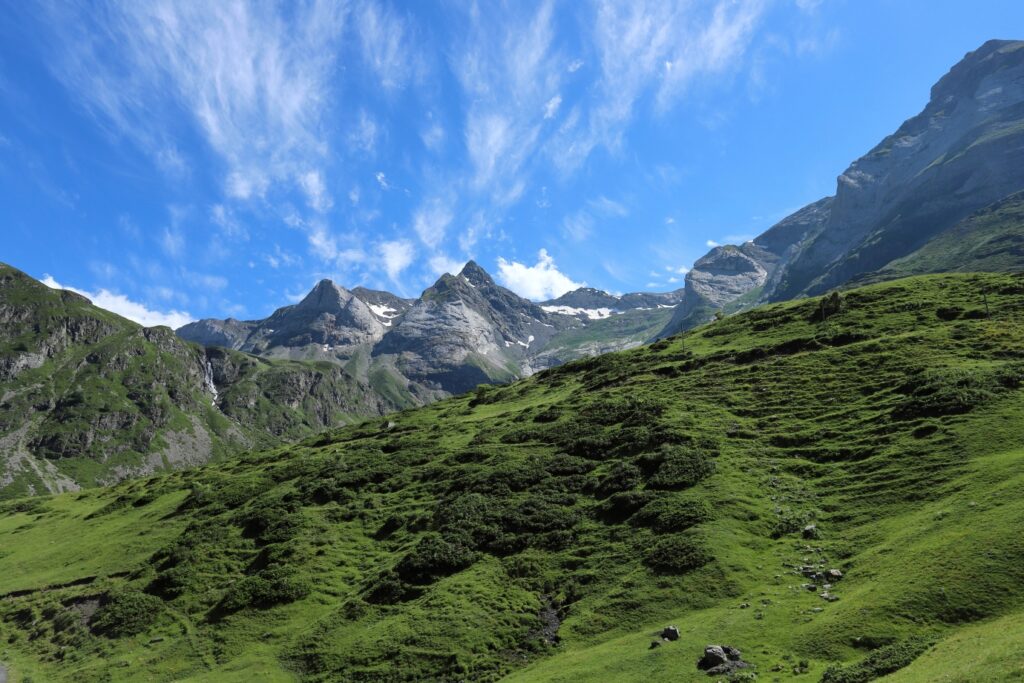 paysage de montagne avec des sommets bas, avec de la végétation et des sommets plus hauts en pierre