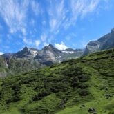 paysage de montagne avec des sommets bas, avec de la végétation et des sommets plus hauts en pierre