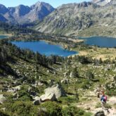 Paysage montagnard avec des lacs en contrebas, entouré de verdure, avec des sommets à l'arrière-plan