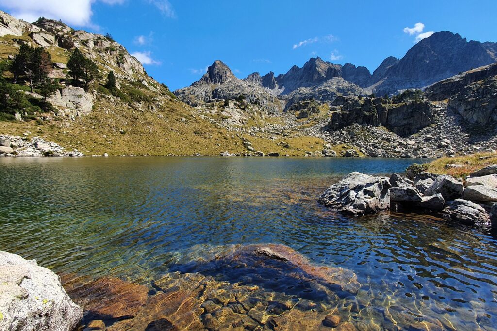 Randonneurs autour d'un lac de montagne lors d'un séjour de randonnée accompagnés d'un guide de montagne