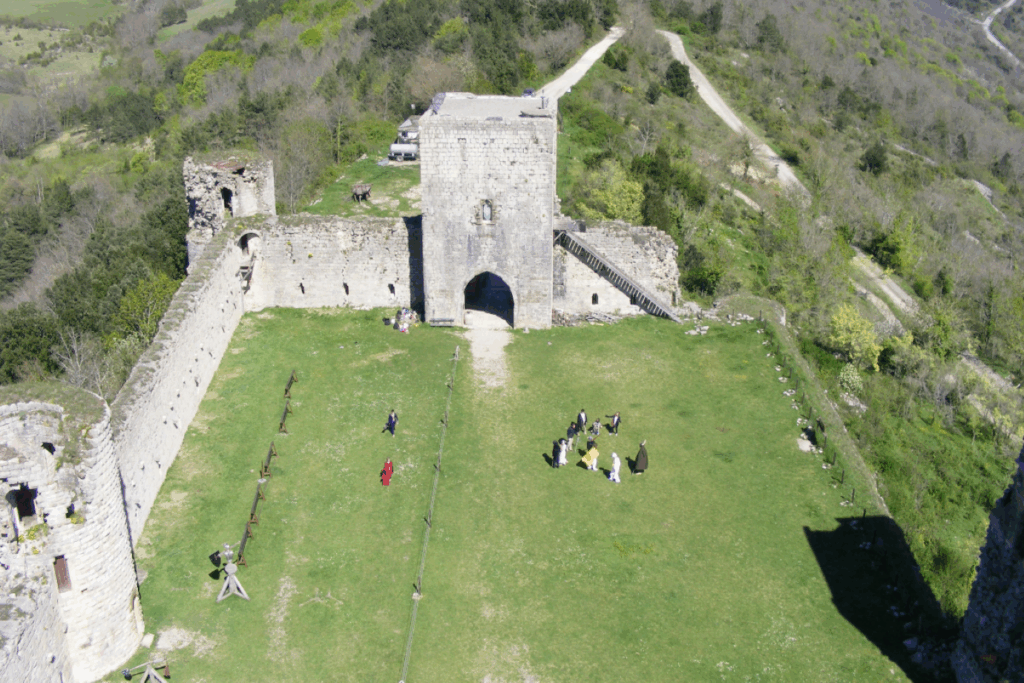 groupe de randonneurs pris de haut en photo, les randonneurs sont alors dans les ruines d'un fort cathare