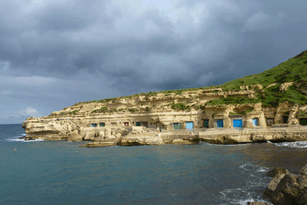 Paysage de la côte sur les îles de Malte et Gozo pris depuis la mer, on y voit un port avec des constructions aux portes bleues
