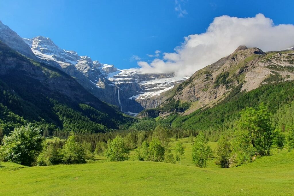 paysage cirque de Gavarnie en été avec une plaine verdoyante avec des arbres