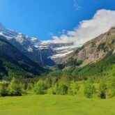 paysage cirque de Gavarnie en été avec une plaine verdoyante avec des arbres