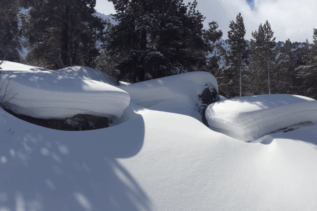 paysage où l'on voit les différentes couches de neige du manteau neigeux sur des roches