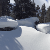 paysage où l'on voit les différentes couches de neige du manteau neigeux sur des roches