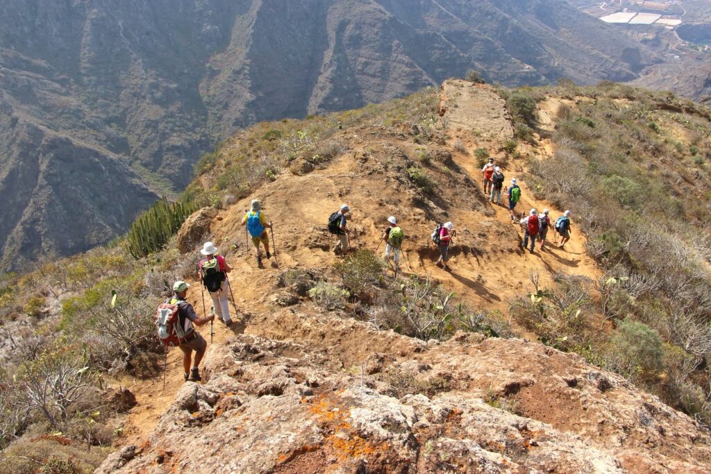 Groupe de randonneurs sur un sentier qui descend une montagne dans les canaries