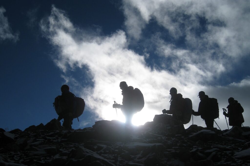 Groupe de randonneurs pris en photo à contrejour, en train de marcher sur une crête sur le massif de l'Annapurna