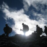 Groupe de randonneurs pris en photo à contrejour, en train de marcher sur une crête sur le massif de l'Annapurna