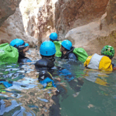 Groupe de personnes qui sont dans l'eau dans un rio, qui font du canyoning avec leur guide