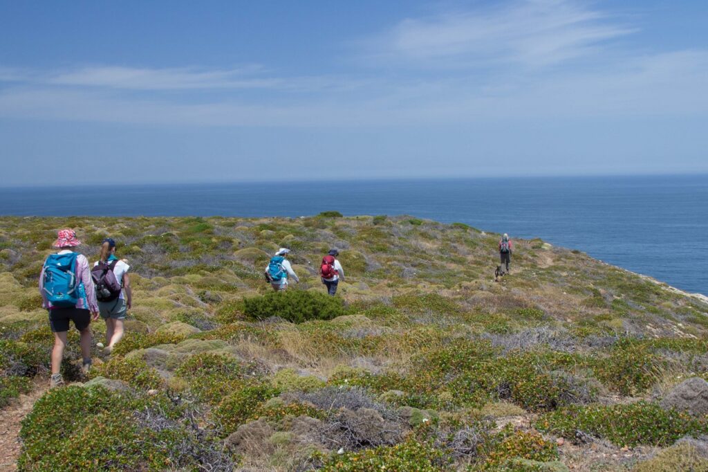 Groupe de randonneurs sur un sentier de randonnée en montagne au Portugal, dans la région de l'Algarve, avec en fond l'eau