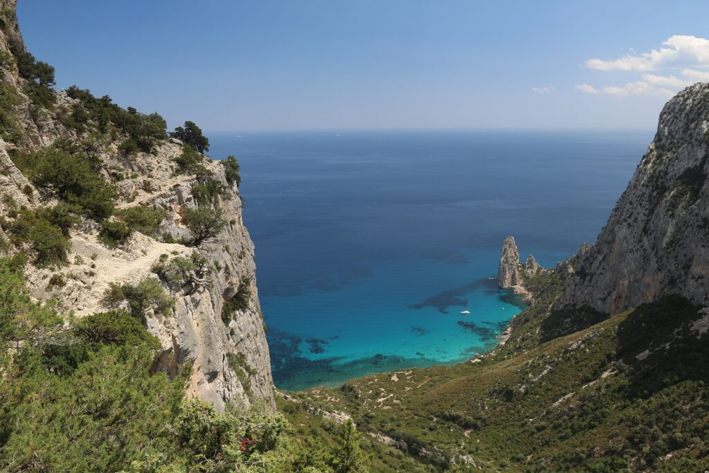 Paysage de montagne avec en contrebas la mer de couleurs turquoise, encadré de différents sommets