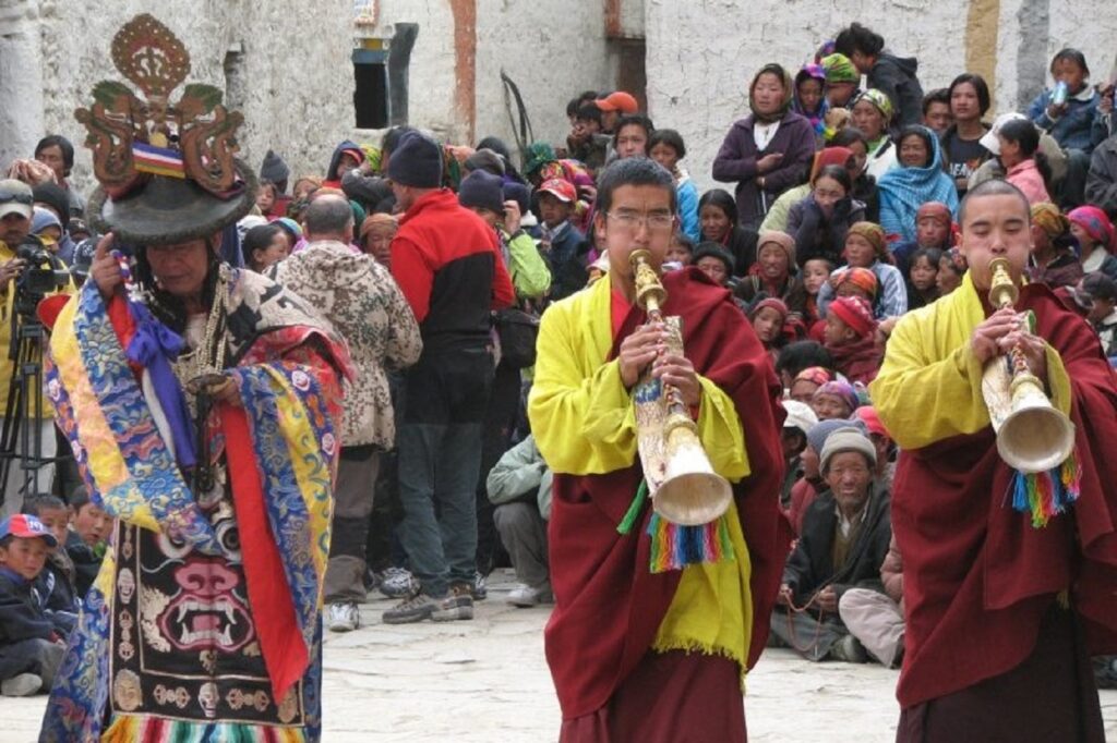 Festivité lors du festival tiji avec des instruments de musique ainsi que le public du village