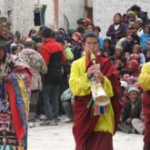 Festivité lors du festival tiji avec des instruments de musique ainsi que le public du village