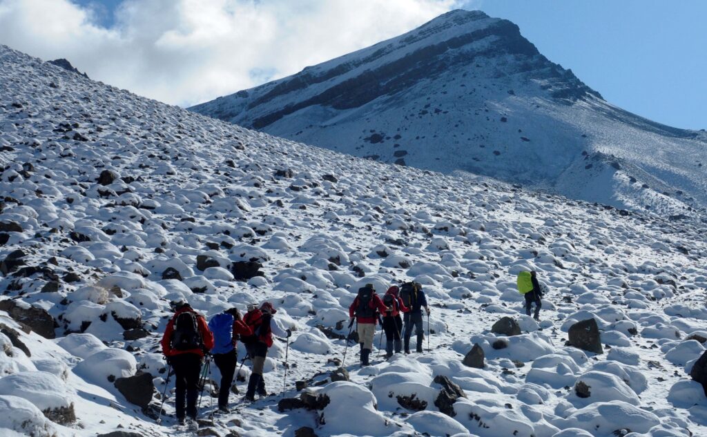 Groupe de snowboarders en train de réaliser l'ascension du toubkal sur la neige avec leur guide