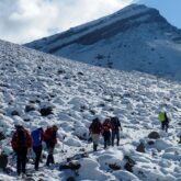 Groupe de snowboarders en train de réaliser l'ascension du toubkal sur la neige avec leur guide
