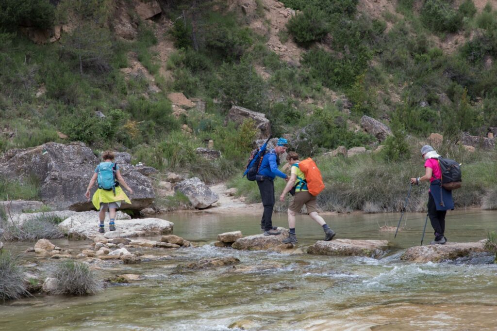 Groupe de randonneurs lors d'un séjour en liberté qui traversent l'eau d'un canyon au cours de leur randonnée