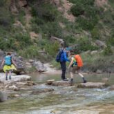 Groupe de randonneurs lors d'un séjour en liberté qui traversent l'eau d'un canyon au cours de leur randonnée