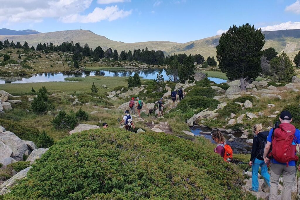 groupe de randonneurs qui marchent vers un lac de montagne