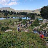 groupe de randonneurs qui marchent vers un lac de montagne