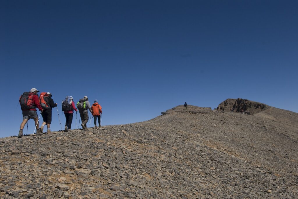 Groupe de randonneurs sur un sentier de randonnée se dirigeant vers le sommet du M'goun qui se situe au bout de la crête