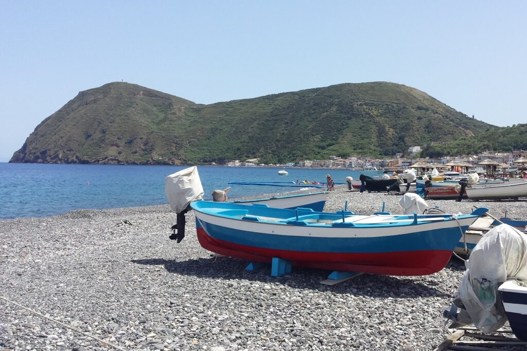 Bateaux à quai sur les îles éoliennes avec des sommets en fond