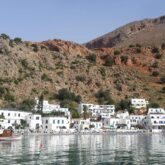 Paysage en Crète avec des maisons blanches au premier plan et des montagnes au-dessus