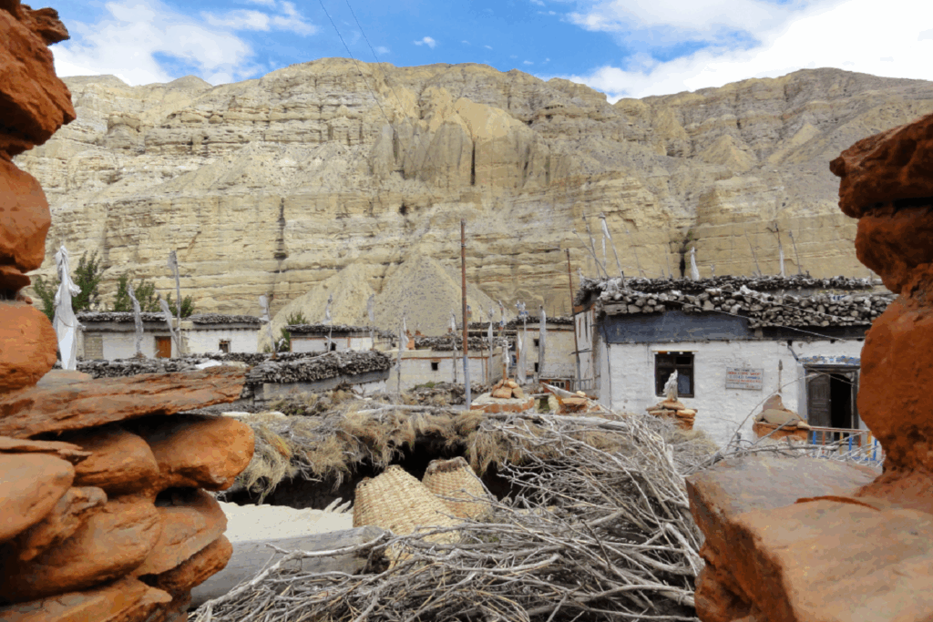 Paysage dans la zone du Mustang au Népal, avec des habitations ainsi que des roches de couleurs orangées