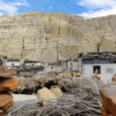 Paysage dans la zone du Mustang au Népal, avec des habitations ainsi que des roches de couleurs orangées