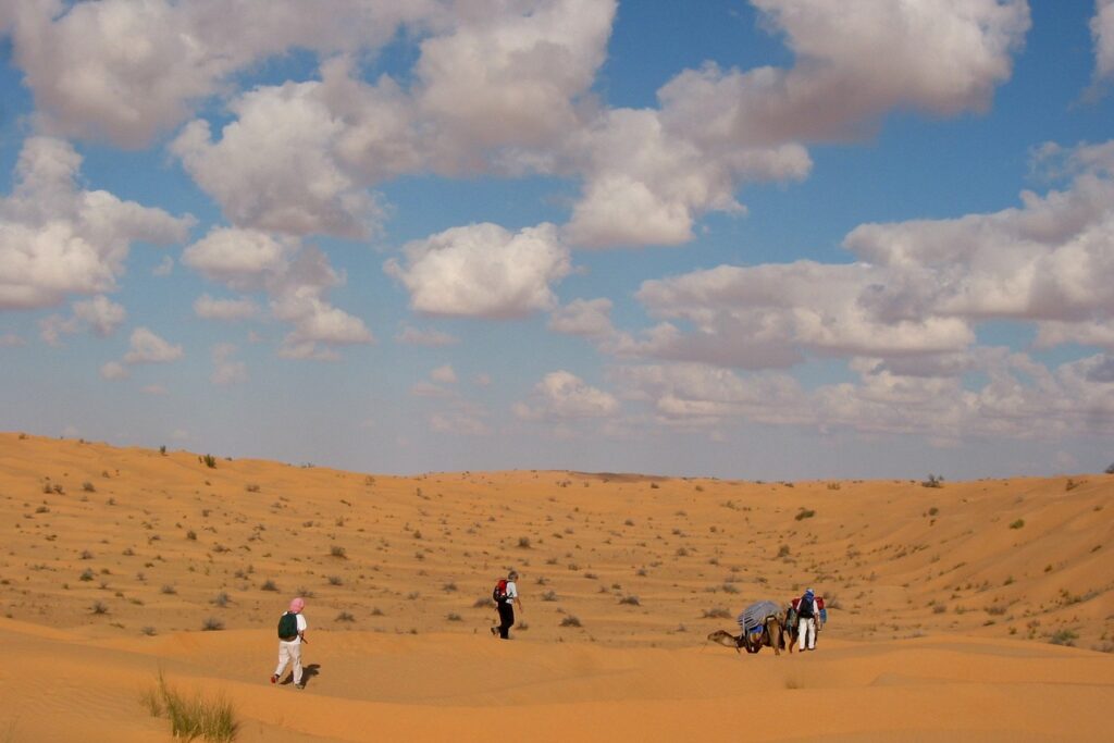 Groupe de randonneurs avec leur guide lors d'un trek dans les dunes du Merzouga