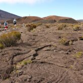 Paysage de la réunion avec un groupe de randonneurs qui marche sur des terres volcaniques