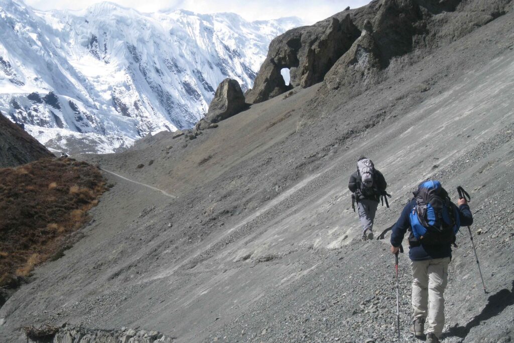Groupe de randonneurs sur un sentier dans les Annapurnas, avec en fond des montagnes couvertes de neige