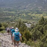 groupe de marcheurs qui, pendant leur trek en liberté en sierra deguar, descendent un chemin de pierre à flanc d'une montagne