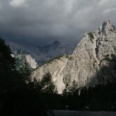 Paysage des Alpes Slovènes appelé le massif des Alpes Juliennes, au premier plan on voit une forêt et à l'arrière-plan des sommets divers
